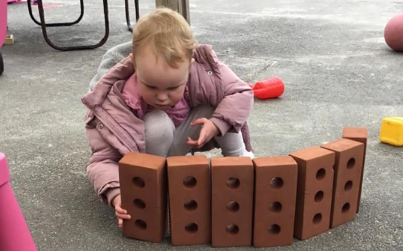 Child making a wall of bricks