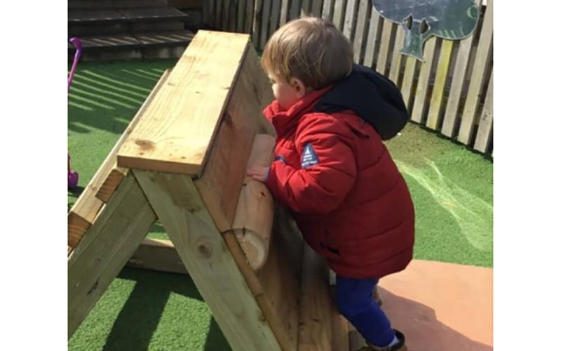 Child climbing a wooden frame