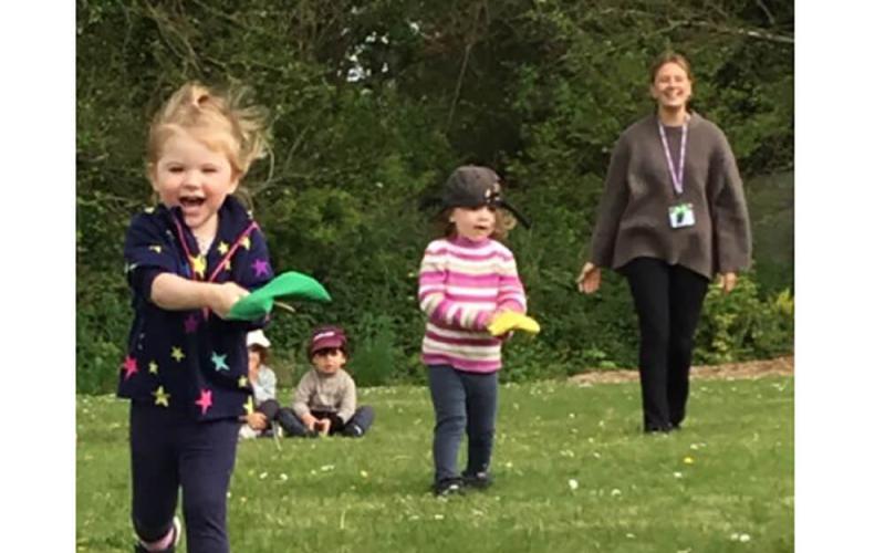 Children doing an egg and spoon race with small coloured bean bags